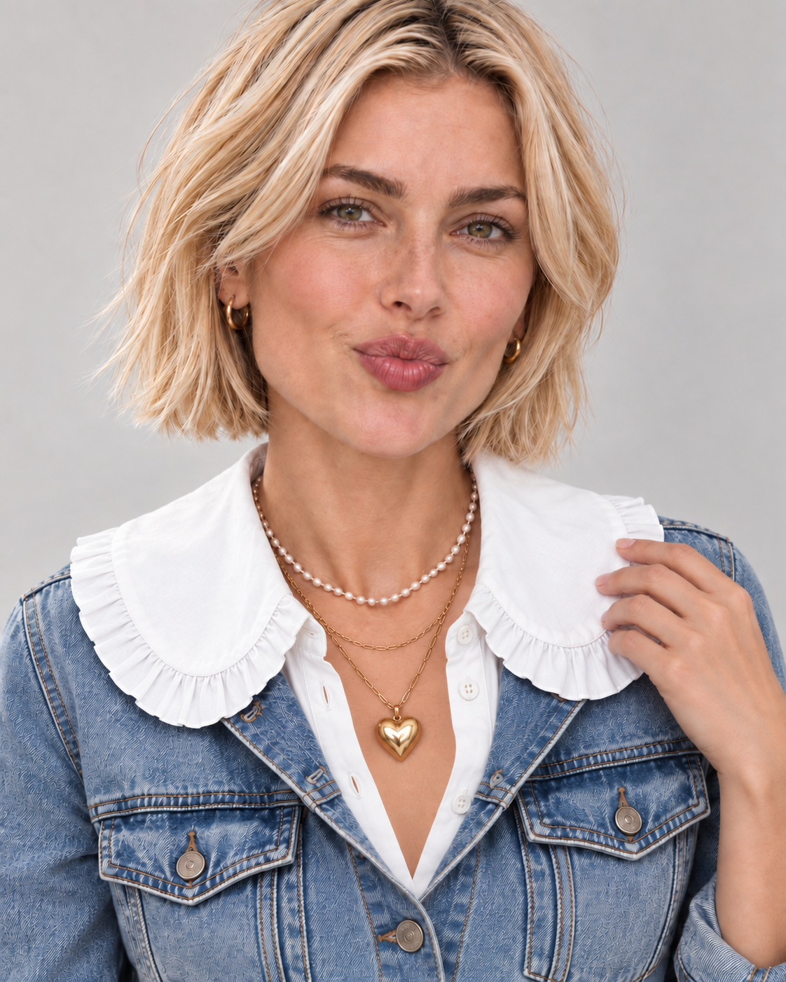 A woman with short blonde hair models a trendy large ruffle white collar, over a faded vintage blue denim jacket.