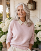 Woman wearing a pink sweater with a pearl collar by the Curated Collar in front of white hydrangeas in Tennessee
