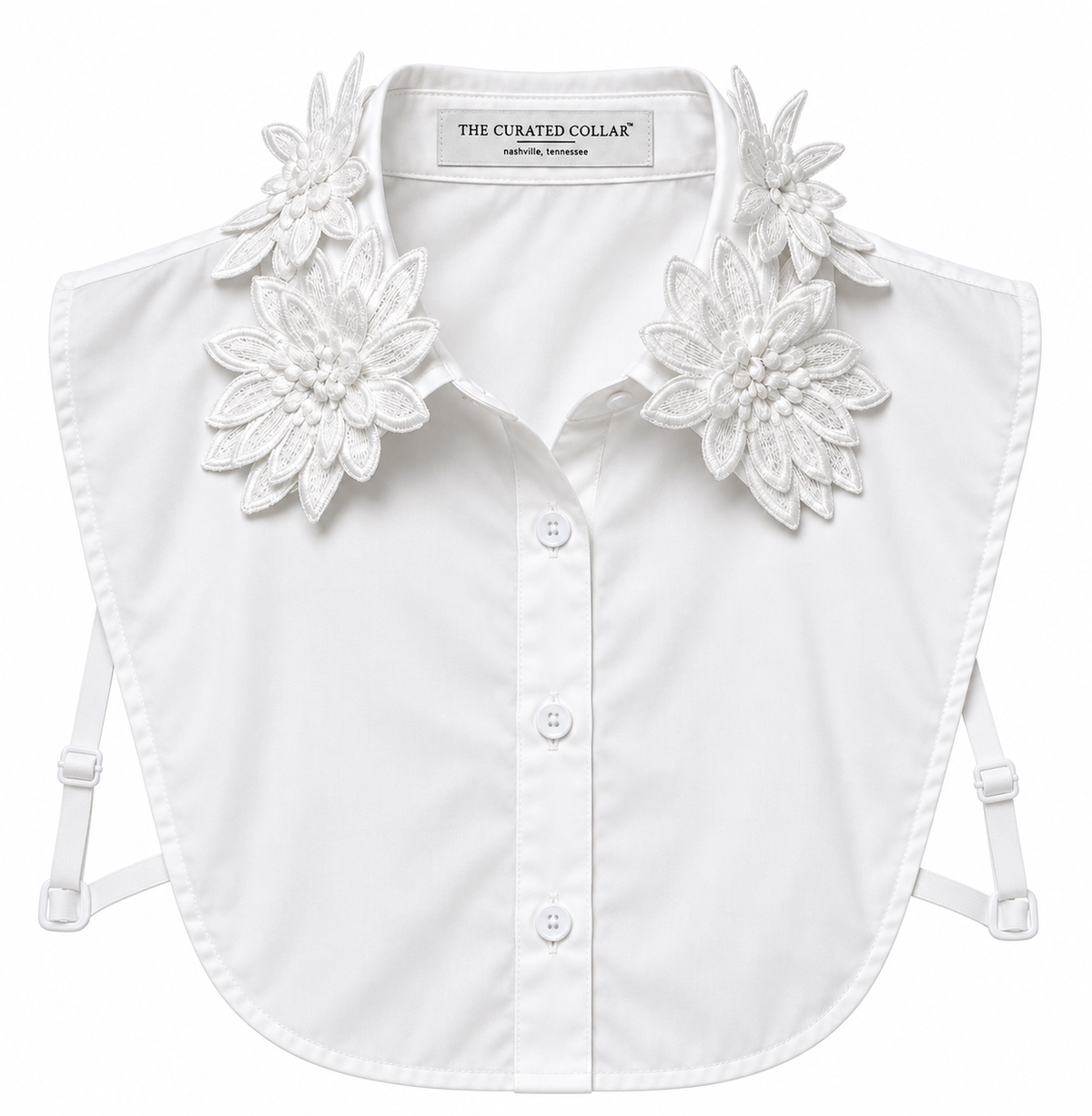White button-front ladies dickey with large embroidered floral collar details and side torso adjustable straps, shown on a plain white background. The neck label reads The Curated Collar.
