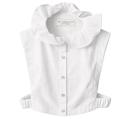 A white sleeveless dickey with a high neck  ruffled collar, button-front center, and elasticized side seams, shown on a plain white background. The inner neck label reads The Curated Collar, Nashville TN.  
